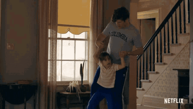 a man in a columbia shirt is holding a little girl
