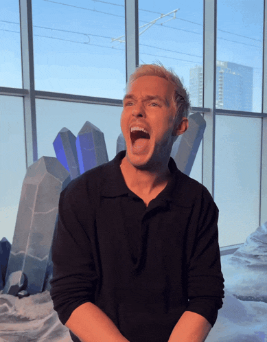 a man in a black shirt with his mouth open