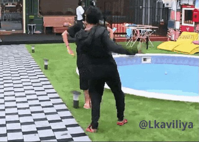 a man is standing in front of a swimming pool with the hashtag lkavicliya