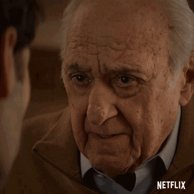 a close up of an older man 's face with a netflix logo on the bottom