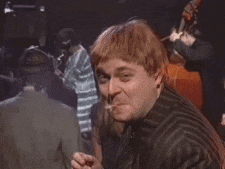 a man is giving a thumbs up sign in a crowded room .