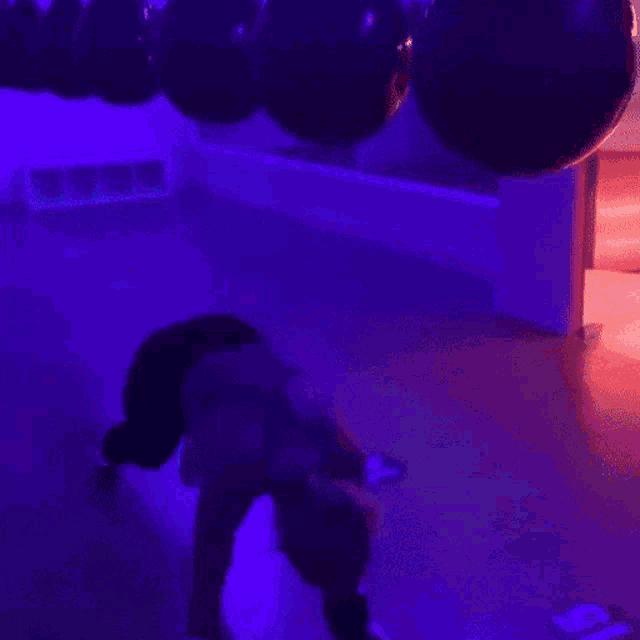 a person is boxing in a dark room with purple lights behind them