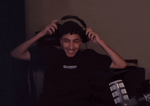 a man wearing headphones and a shirt that says souvenir is smiling