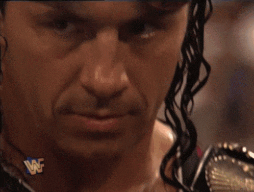 a close up of a man 's face with a wwe logo on his ear