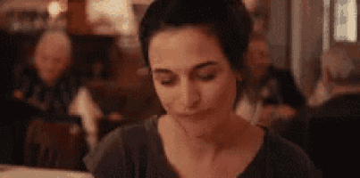 a woman is sitting at a table in a restaurant eating a meal .