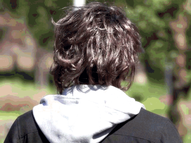 the back of a person 's head with a grey hoodie on