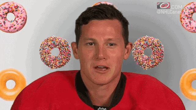 a man in a red jersey is surrounded by donuts and sprinkles