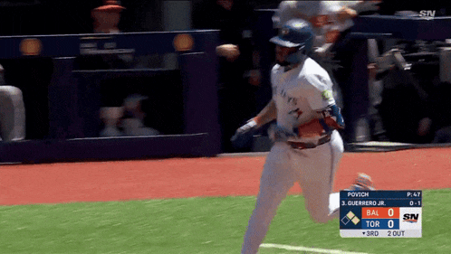 a baseball player in a blue jays uniform is running