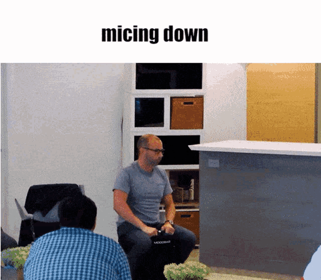 a man sitting in a chair with the word micing down on the top
