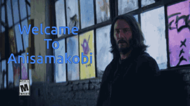 a man stands in front of a window with the words welcome to anisamakobi written on it