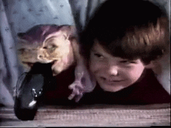 a young boy is playing with a stuffed animal while another child looks on