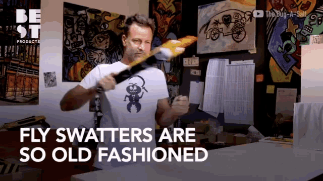 a man in a white shirt with a bug on it says fly swatters are so old fashioned in a video
