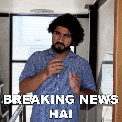 a man with a beard is holding a glass with the words breaking news hai below him
