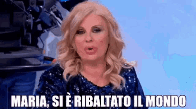 a woman in a blue dress says maria si e ribaltato il mondo