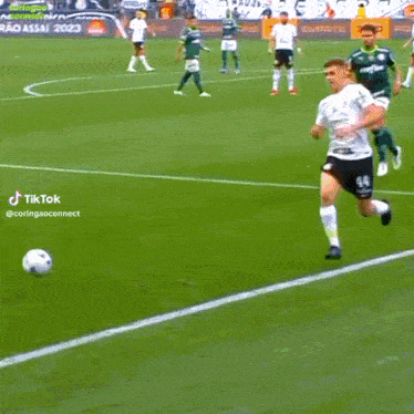 a soccer game is being played on a field with an ad for tiktok in the background