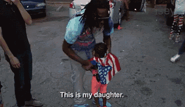 a man is holding a little girl in an american flag costume .