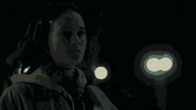 a woman in a dark room with a light behind her that says ' infinity '