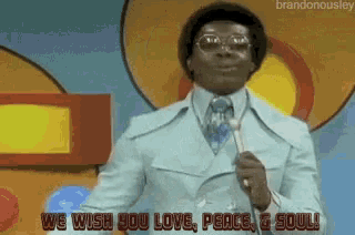 a man singing into a microphone with the words we wish you love peace and soul behind him