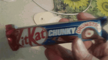 someone is holding a kitkat chunky candy bar