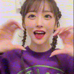 a woman with pigtails is wearing a purple sweater and making a face .