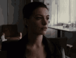 a close up of a woman 's face in a dark room looking at the camera .