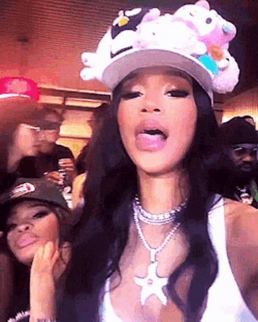 a woman wearing a hello kitty hat is taking a selfie with another woman .