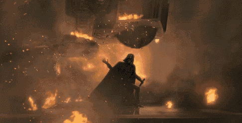 a man in a black cape is standing in front of a fire and smoke .
