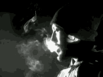 a man is smoking a cigarette in a dark room .