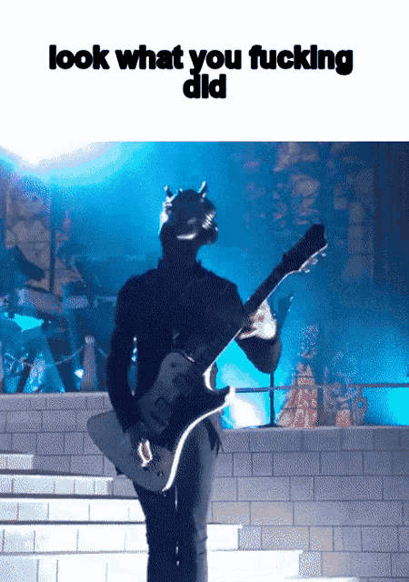 a picture of a man playing a guitar with the words look what you fucking did above him