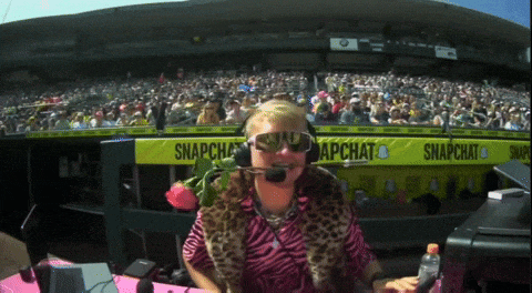 a woman wearing headphones and sunglasses stands in front of a banner that says snapchat