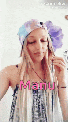 a woman wearing a hat and a scarf with the name manu written on her face