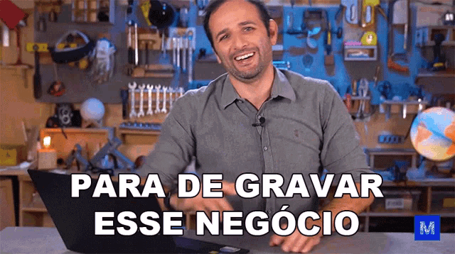 a man sitting in front of a laptop with the words para de gravar esse negocio written on the screen
