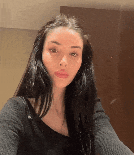 a woman with long black hair is taking a selfie