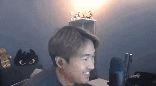a man is smiling in front of a microphone in a room