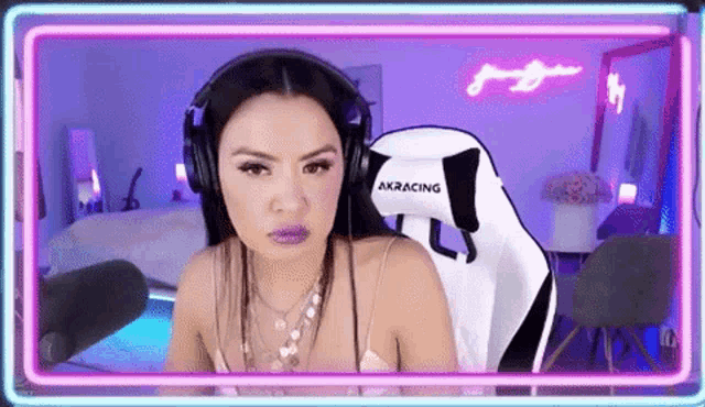 a woman wearing headphones is sitting in a white gaming chair .