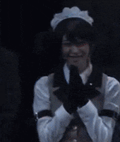 a woman in a maid costume is smiling in a dark room .