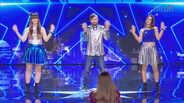 a man and two women are dancing on a stage with talent written on the bottom of the screen