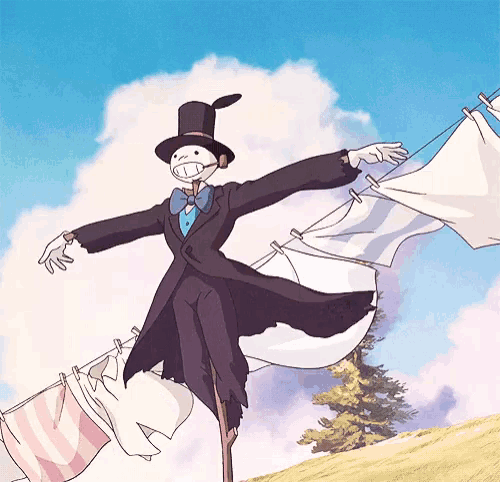 a scarecrow in a top hat is standing next to a clothes line