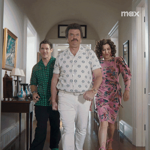 three people are walking down a hallway and the word max is on the bottom