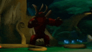 a red dragon is standing next to a tree in a forest .