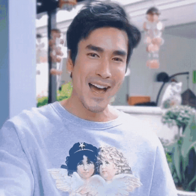 a man wearing a t-shirt with angels on it