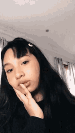 a young girl with long black hair has a clip in her hair