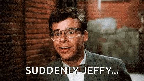 a man wearing glasses and a suit is saying `` suddenly jeffy '' .