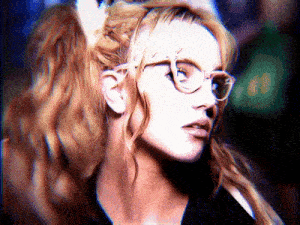 a close up of a woman wearing glasses with a ponytail