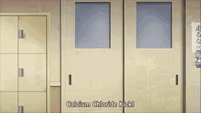 a man is standing in front of a row of lockers and a girl is kicking him in the face .