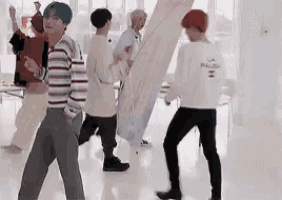 a group of young men are standing in a room and one of them is wearing a white shirt that says la pause