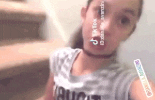 a young girl is taking a selfie in front of stairs .