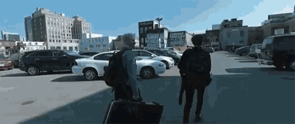 two people walking in a parking lot with a briefcase that says ytc on it .