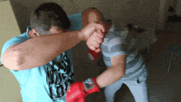 a man wearing a shirt that says ' dirty boys ' on it is boxing another man