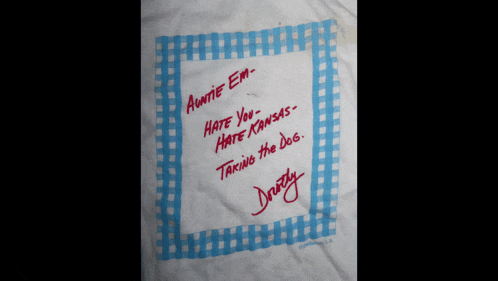 a piece of paper that says auntie em hate you hate kansas taking in the dog